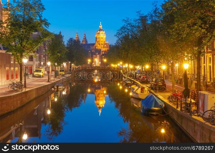 Night red-light district De Wallen, canal Oudezijds Voorburgwal, bridge, Basilica of Saint Nicholas and its mirror reflection, Amsterdam, Holland, Netherlands. Long exposure.