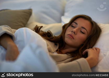 night, rest, comfort and people concept - young woman sleeping in bed at home