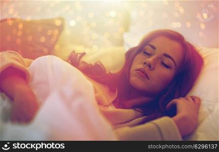 night, rest, comfort and people concept - young woman sleeping in bed at home. young woman sleeping in bed at home