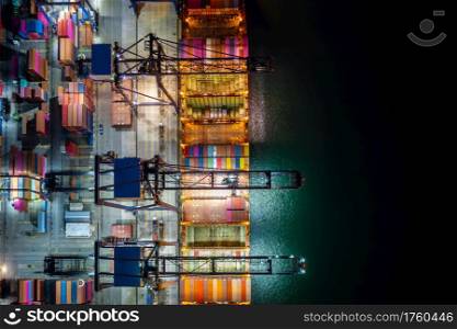 Night scene Container ship loading and unloading in deep sea port, Aerial view of business service and industry cargo logistic import and export freight transportation by container ship in open sea, Container loading Cargo freight ship.