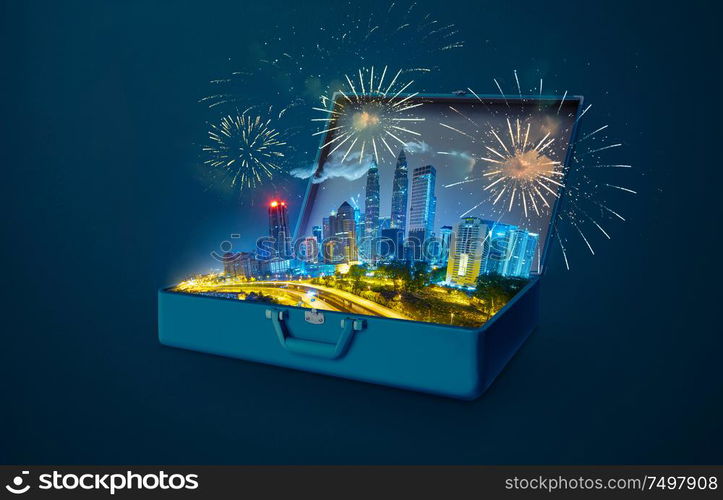 Night scene modern city skyscraper with fireworks in an open retro vintage suitcase isolated on blue background .