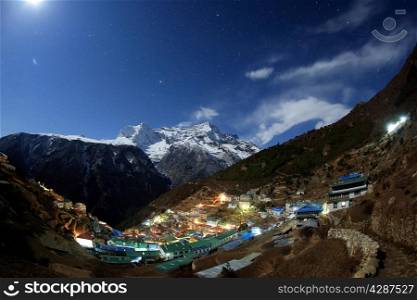 Night sky and stars passing by behind mountain Kongde Ri, Namche Bazaar village. Nepal.&#xA;