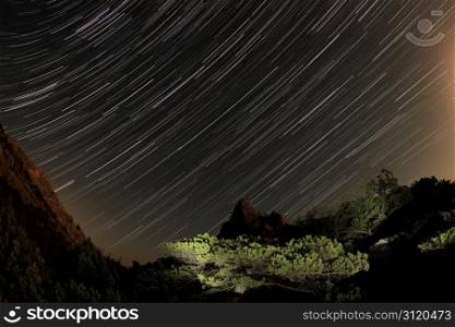 night sky with clouds and stars passing by behind mountain. Noviy Svet, Crimea, Ukraine