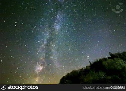 Night sky with stars and milky way over hill