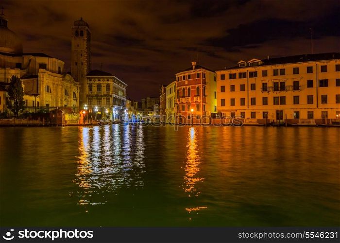 Night time view of the Grand Canal in Venice, with one of the many churches on the left and private apartments and hotel rooms on the right.