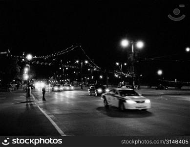 Night Traffic With A City Bridge In The Background