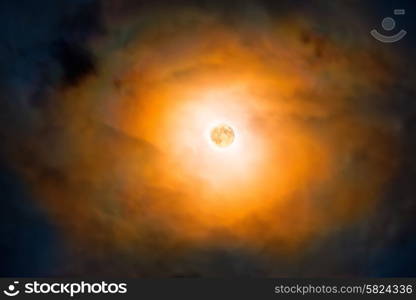 Night view at the full moon through moving orange clouds. Abstract scene