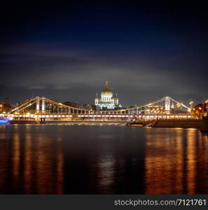 Night view at the main Russian Cathedral of Christ the Savior and the Krymsky Bridge from the embankment of Gorky Park, Moscow, Russia