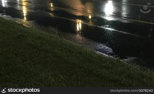 Night view of car traffic on the wet road with puddles