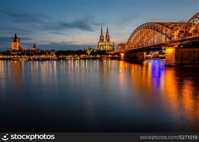 Night View of Cologne Cathedral (Kolner Dom) and Rhine river under the Hohenzollern Bridge, Cologne city skyline at night, North Rhine Westphalia region, Germany.
