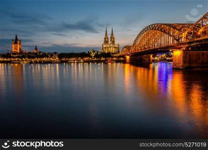 Night View of Cologne Cathedral (Kolner Dom) and Rhine river under the Hohenzollern Bridge, Cologne city skyline at night, North Rhine Westphalia region, Germany.