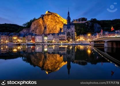 Night view of Dinant town, Collegiate Church of Notre Dame de Dinant over River Meuse and Pont Charles de Gaulle bridge and Dinant Citadel illuminated in the evening. Dinant, Belgium. Night view of Dinant town, Belgium