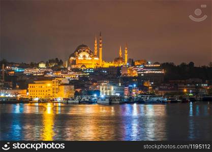 Night view of Istanbul cityscape Suleymaniye Mosque (Rustem Pasha Mosque) with floating tourist boats in Bosphorus ,Istanbul Turkey