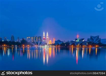 Night view of Kuala Lumpur city skyline with reflection in water