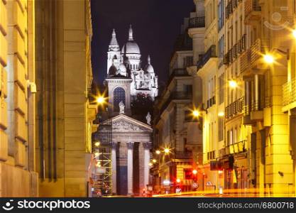 Night view of Sacre-Coeur Basilica or Basilica of the Sacred Heart of Jesus and Notre-Dame de Lorette church, seen from Rue Laffitte, Paris, France