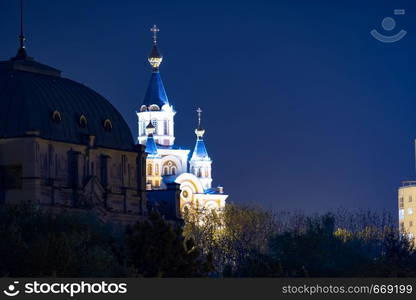 Night View of the city of Khabarovsk from the Amur river. Blue night sky. The night city is brightly lit with lanterns.