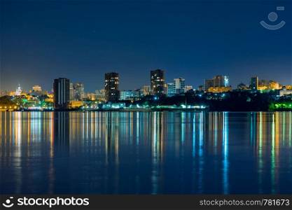 Night View of the city of Khabarovsk from the Amur river. Blue night sky. The night city is brightly lit with lanterns. Night View of the city of Khabarovsk from the Amur river. Blue night sky. The night city is brightly lit with lanterns.
