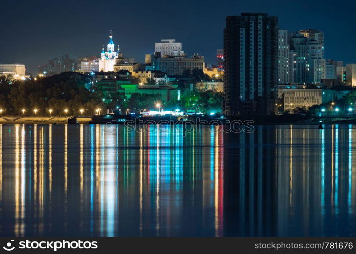 Night View of the city of Khabarovsk from the Amur river. Blue night sky. The night city is brightly lit with lanterns. Night View of the city of Khabarovsk from the Amur river. Blue night sky. The night city is brightly lit with lanterns.