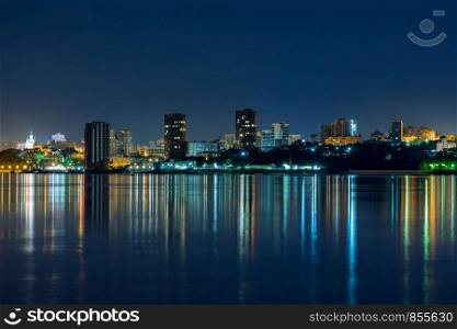 Night View of the city of Khabarovsk from the Amur river. Blue night sky. The night city is brightly lit with lanterns. Night View of the city of Khabarovsk from the Amur river. Blue night sky. The night city is brightly lit with lanterns. The level of the Amur river at around 159 centimeters.
