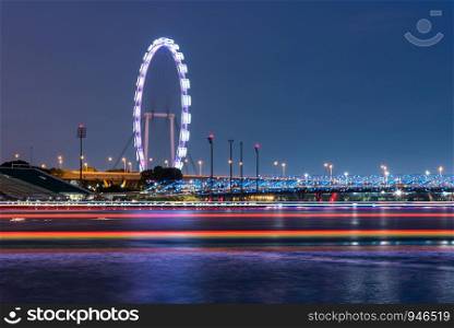 Night view of the marina bay with the giant ferris wheel in Singapore.
