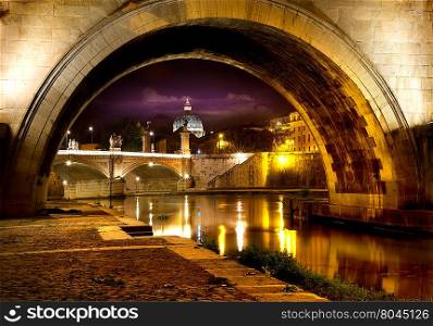 Night view on the Sant Angelo Bridge and Basilica of St. Peter in Rome, Italy