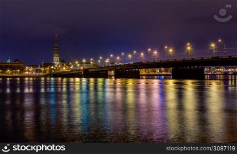 Night view to the historical city center and Stone bridge from the banks of Daugava river colored with street lights, Riga, Latvia