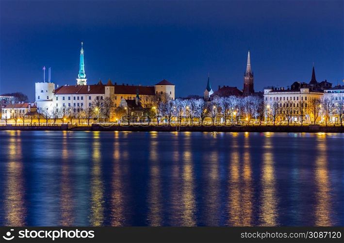 Night view to the historical city center with castle and churches from the banks of Daugava river colored with street lights, Riga, Latvia