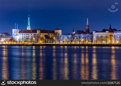 Night view to the historical city center with castle and churches from the banks of Daugava river colored with street lights, Riga, Latvia