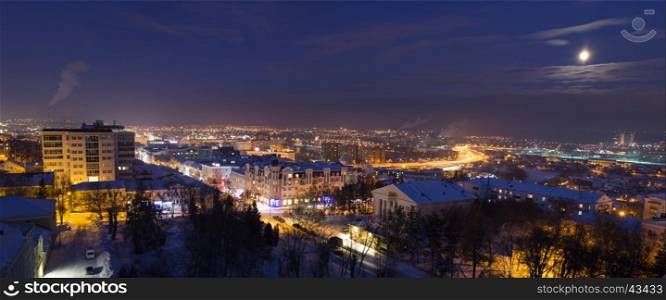 Night winter panorama of the Penza city in a full moon, with illuminated residential areas an highway, a top view, Russia