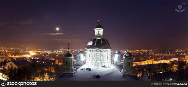 Night winter panorama of the Penza city in a full moon, with illuminated orthodox cathedral on the foreground and residential areas and highway, a top view, Russia