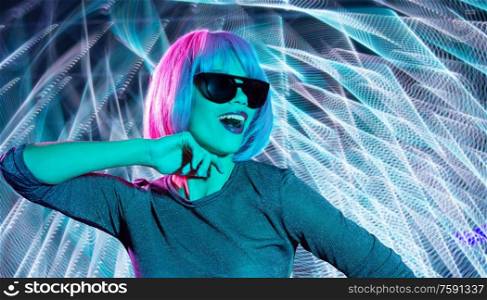 nightlife, fashion and people concept - happy young woman wearing pink wig and black sunglasses in neon ultra violet light over neon lights background. happy woman in pink wig and black sunglasses