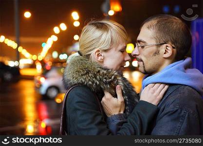 nightly street of coldly fall city. man and woman is embracing.