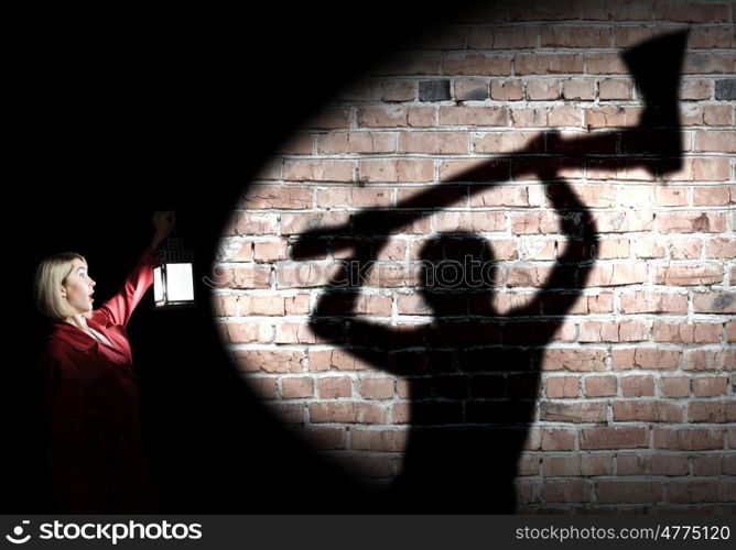 Nightmare. Young blond woman in red cloak with lantern