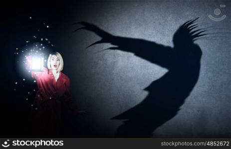 Nightmare. Young blond woman in red cloak with lantern