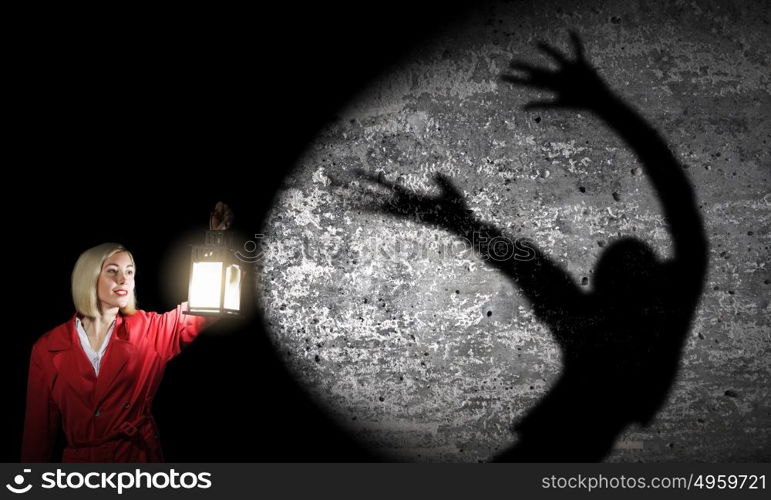 Nightmare. Young blond woman in red cloak with lantern