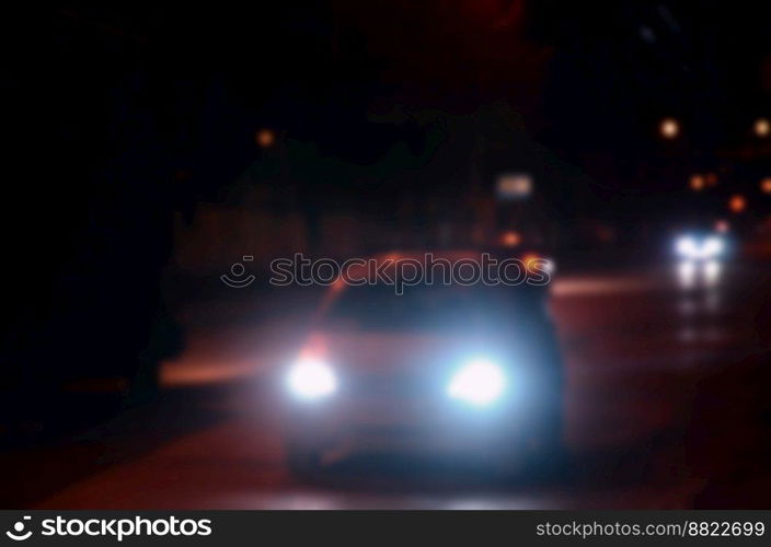 Nights lights of the big city, the blurred night avenue with bokeh traffic lights and headlights of the approaching cars. Blurred landscape of night city