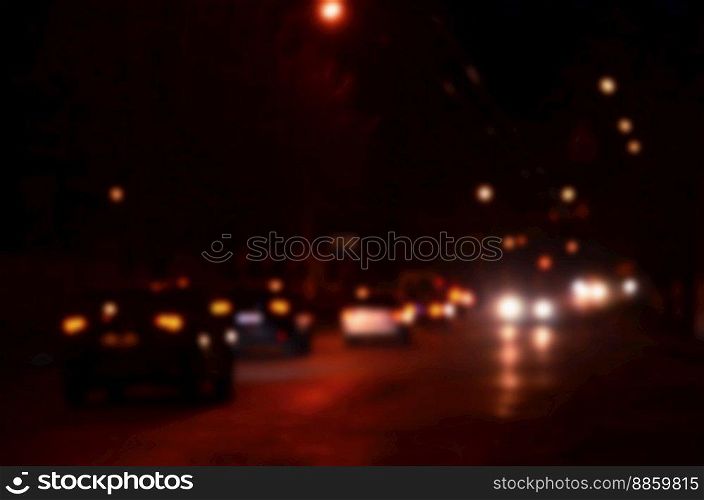 Nights lights of the big city, the blurred night avenue with bokeh traffic lights and headlights of the approaching cars. Blurred landscape of night city