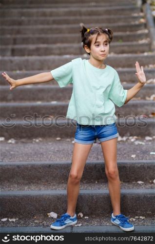 Nine-year-old girl dancing on the steps of a city park.. Nine-year-old girl dancing on the steps outdoors