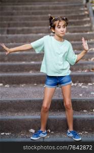 Nine-year-old girl dancing on the steps of a city park.. Nine-year-old girl dancing on the steps outdoors