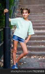 Nine-year-old girl standing on the steps of a city park.. Nine-year-old girl standing on the steps outdoors