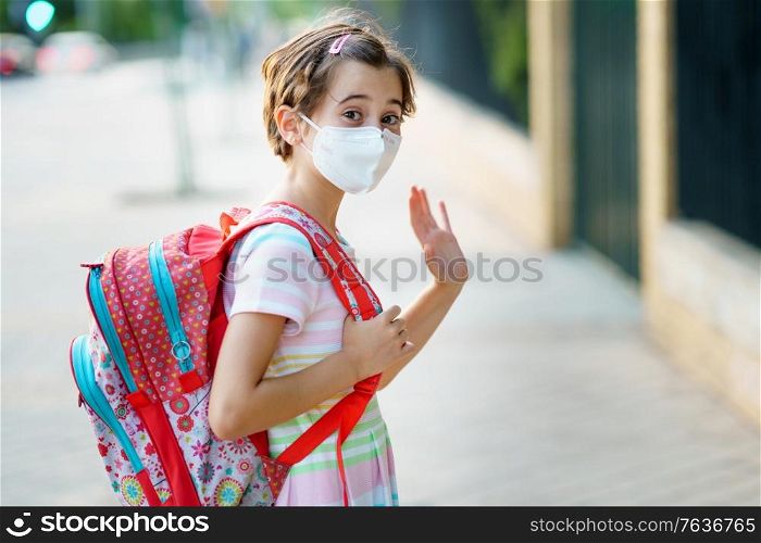 Nine years old girl goes back to school wearing a mask and a schoolbag outdoors.. Nine years old girl goes back to school wearing a mask and a schoolbag.