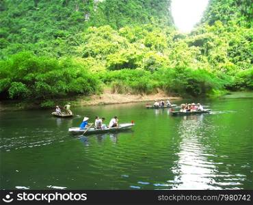 NINH BINH, VIETNAM, JULY, 20: Unidentified tourists in Trang An on JULY, 20, 2013. Trang An is the scenic area, ranked special of Vietnam.