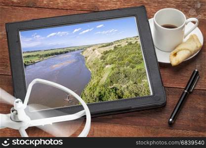 Niobrara River in Nebraska Sand Hills - reviewing an aerial picture on a digital tablet with a drone propeller and coffee, screen picture copyright by the photographer