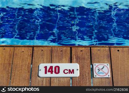 no diving and depth sign warning at swimming pool edge with copy space