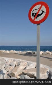 no fishing allowed sign on stone pier (ocean and sky background)