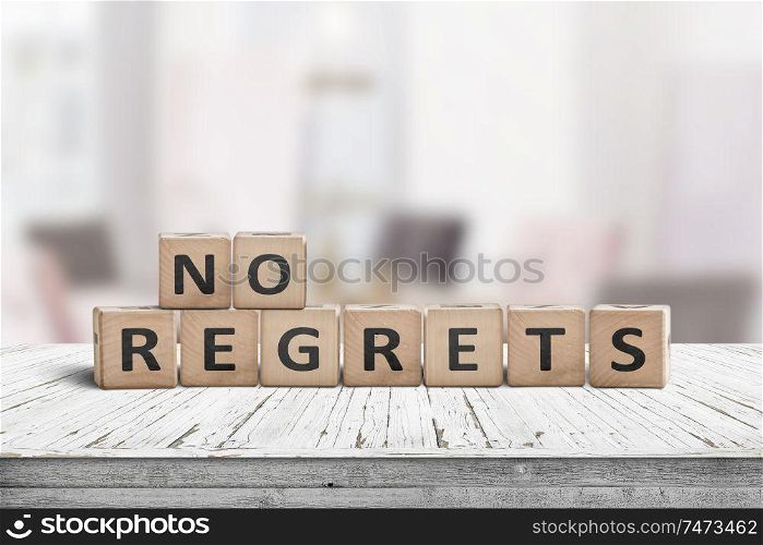 No regrets sign made with wooden blocks on a table in a bright room