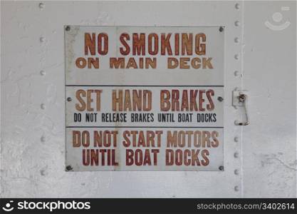 no smoking and instructions sign on a white still wall of old ferry ship Eureka in San Francisco Maritime National Historical Park