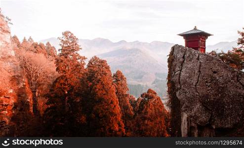 Nokyodo red sutra repository building on rock cliff in evening at Yamadera Risshaku ji temple. Yamagata - Japan