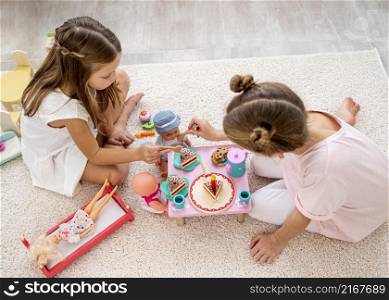 non binary children playing birthday game with baby dolls