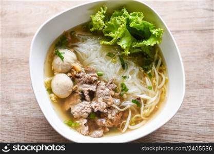 Noodle soup bowl fresh vegetable lettuce pork and Pork balls on wooden background, Thai traditional menu food
